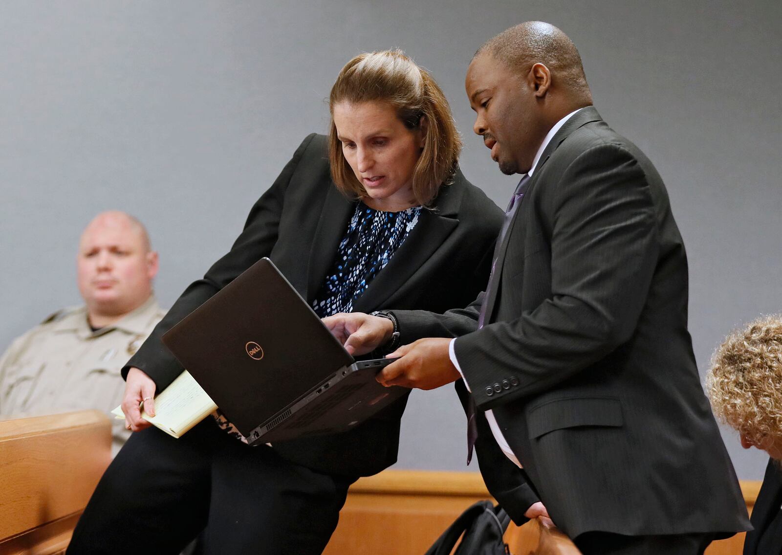 Emily Gilbert and Brad Gardner, state capital public defenders, confer while presenting a motion to meet privately with Judge George Hutchinson outside the presence of the prosecution.