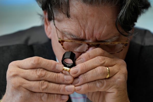 Appraiser Kaja Veilleux examines jewelry for a client at Thomaston Place Auction Galleries, Tuesday, Nov. 19, 2024, in Thomaston, Maine. (AP Photo/Robert F. Bukaty)