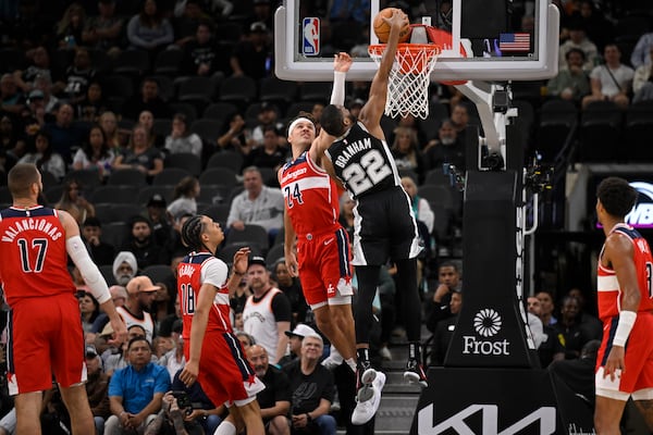 San Antonio Spurs' Malaki Branham (22) dunks against Washington Wizards' Corey Kispert (24) during the first half of an NBA basketball game, Thursday, Nov. 13, 2024, in San Antonio. (AP Photo/Darren Abate)