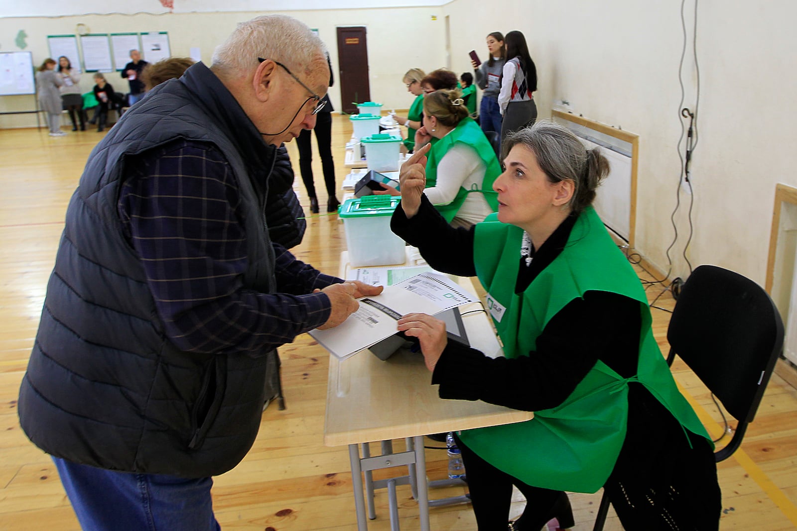 A man gets his ballot at a polling station during the parliamentary election in Tbilisi, Georgia, Saturday, Oct. 26, 2024. (AP Photo/Shakh Aivazov)