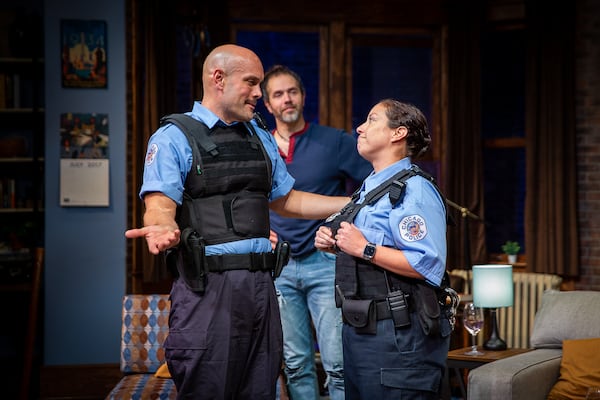 Officers Novak (Brad Brinkley) and Caruso (Suehyla E. Young, who shares the role with Kelly Criss) interrogate the Support Group for Men, led by Brian (Louis Kyper, center).