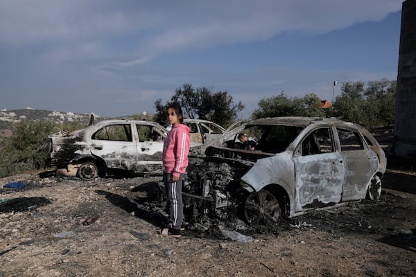 A Palestinian girl looks at a damaged cars following an Israeli airstrike in the West Bank city of Jenin, Thursday, Nov. 21, 2024. (AP Photo/Majdi Mohammed)