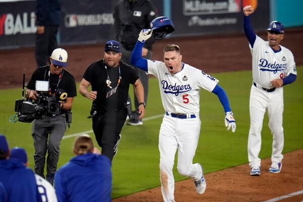 Los Angeles Dodgers' Freddie Freeman (5) celebrates after hitting a game-winning grand slam against the New York Yankees during the 10th inning in Game 1 of the baseball World Series, Friday, Oct. 25, 2024, in Los Angeles. The Dodgers won 6-3. (AP Photo/Julio Cortez)