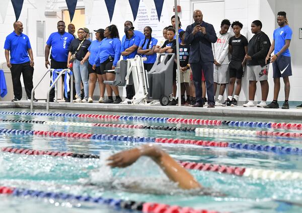 Staff and guests watch as Rev. Gerald Durley (foreground) participates in ceremonial swim during a ribbon cutting ceremony to inaugurate the new pool at Andrew and Walter Young Family YMCA, Wednesday, July 5, 2023, in Atlanta. (Hyosub Shin / Hyosub.Shin@ajc.com)