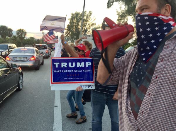 People wave flags and cheer for President Donald Trump on Palm Beach, February 4, 2017. Greg Lovett / Daily News