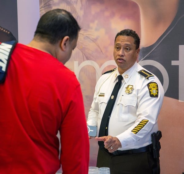 Fulton County Sheriff Patrick Labat talks to a potential recruit at a job fair at LA Fitness in Atlanta Friday, Feb. 11, 2022.    STEVE SCHAEFER FOR THE ATLANTA JOURNAL-CONSTITUTION