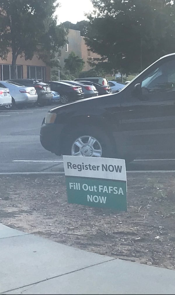 Signs encouraging students to fill out the Free Application for Federal Student Aid are posted on a parking lot of Georgia Gwinnett College. The new period for students to fill out the form begins Oct. 1. ERIC STIRGUS / ESTIRGUS@AJC.COM