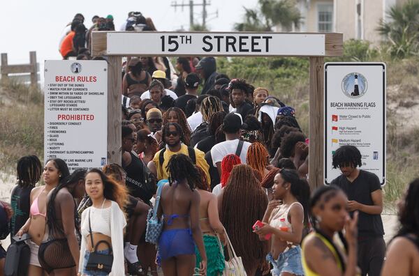 Attendees of Orange Crush in Tybee Island enter and exit the beach on Saturday, April 20, 2024. (Natrice Miller/ AJC)