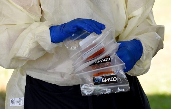 Catherine Spellman, LPN, secures COVID-19 tests conducted July 14, 2020, outside  the Glynn County Health Department in Brunswick.  Ryon Horne/RHORNE@AJC.COM