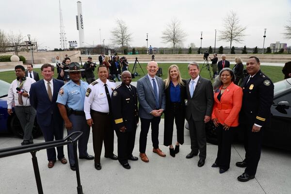 Gov. Brian Kemp and his wife Marty stand with law enforcement officials after Wednesday's news conference.