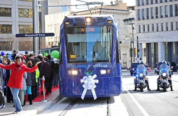 December 30, 2014 Atlanta - Crowds gather as an Atlanta Streetcar arrives during a grand opening ceremony at Woodruff Park on Tuesday, December 30, 2014. After escalating costs and a series of delays, the Atlanta street car finally rolled through a stretch of downtown Atlanta. President Obama's transportation legacy hinges on his ability to move the nation toward rail, and the streetcar is one of the first completed projects aimed at making the nation more rail oriented. And the city sees the streetcar as the first of many streetcars that will create an auxiliary transit system over time, attracting investment and creating jobs. HYOSUB SHIN / HSHIN@AJC.COM