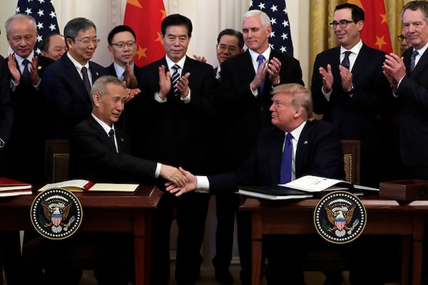 President Donald Trump shakes hands with Chinese Vice Premier Liu He, after signing a trade agreement Wednesday in the East Room of the White House. Trump hailed the long-sought agreement as a "momentous step" that was "righting the wrongs of the past."