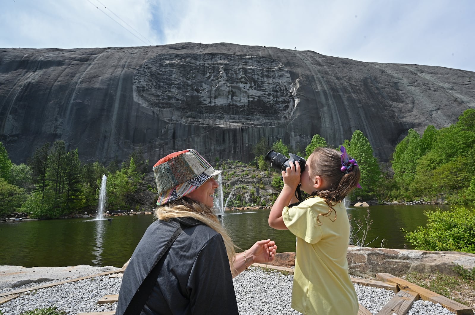 April 20, 2021 Stone Mountain - Pam Topicz watches as her daughter Alayna, 5, takes a picture of Confederate Memorial Carving at Stone Mountain Park on Tuesday, April 20, 2021. Topicz is traveling from Cincinnati, Ohio.  (Hyosub Shin / Hyosub.Shin@ajc.com)