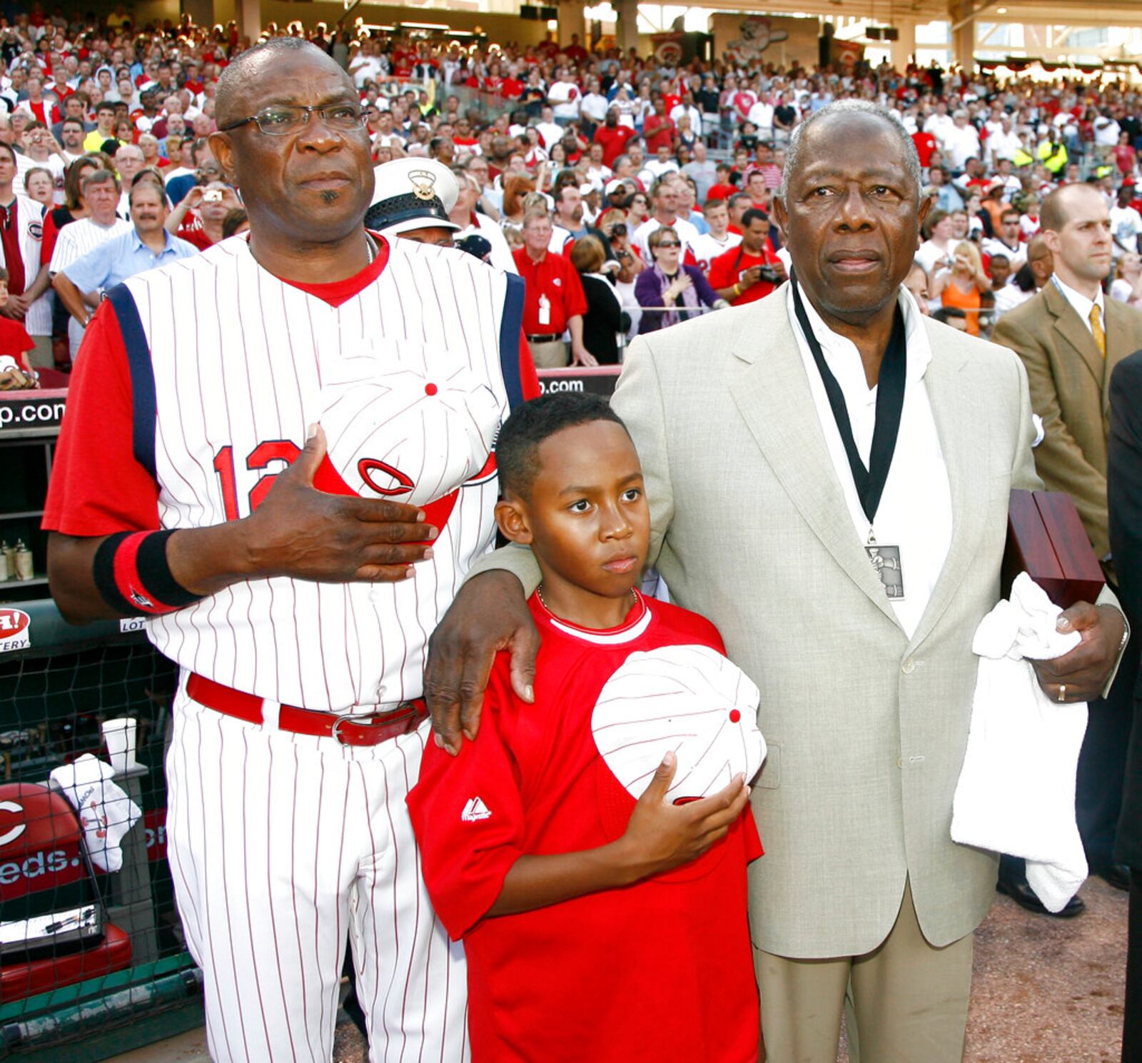 In this 2009 file photo, Reds manager Dusty Baker, left, stands with his son Darren Baker, center, and baseball great Hank Aaron as the national anthem is played at the Civil Rights Game ceremony before a game.   (AP Photo/David Kohl, File)