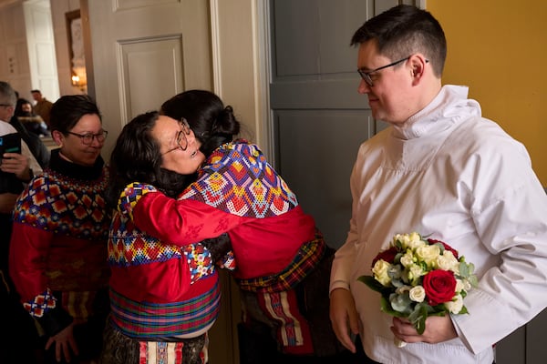 Salik Schmidt and Malu Schmidt welcome relatives and friends during their weeding at the Church of our Savior in Nuuk, Greenland, Saturday, Feb. 15, 2025. (AP Photo/Emilio Morenatti)