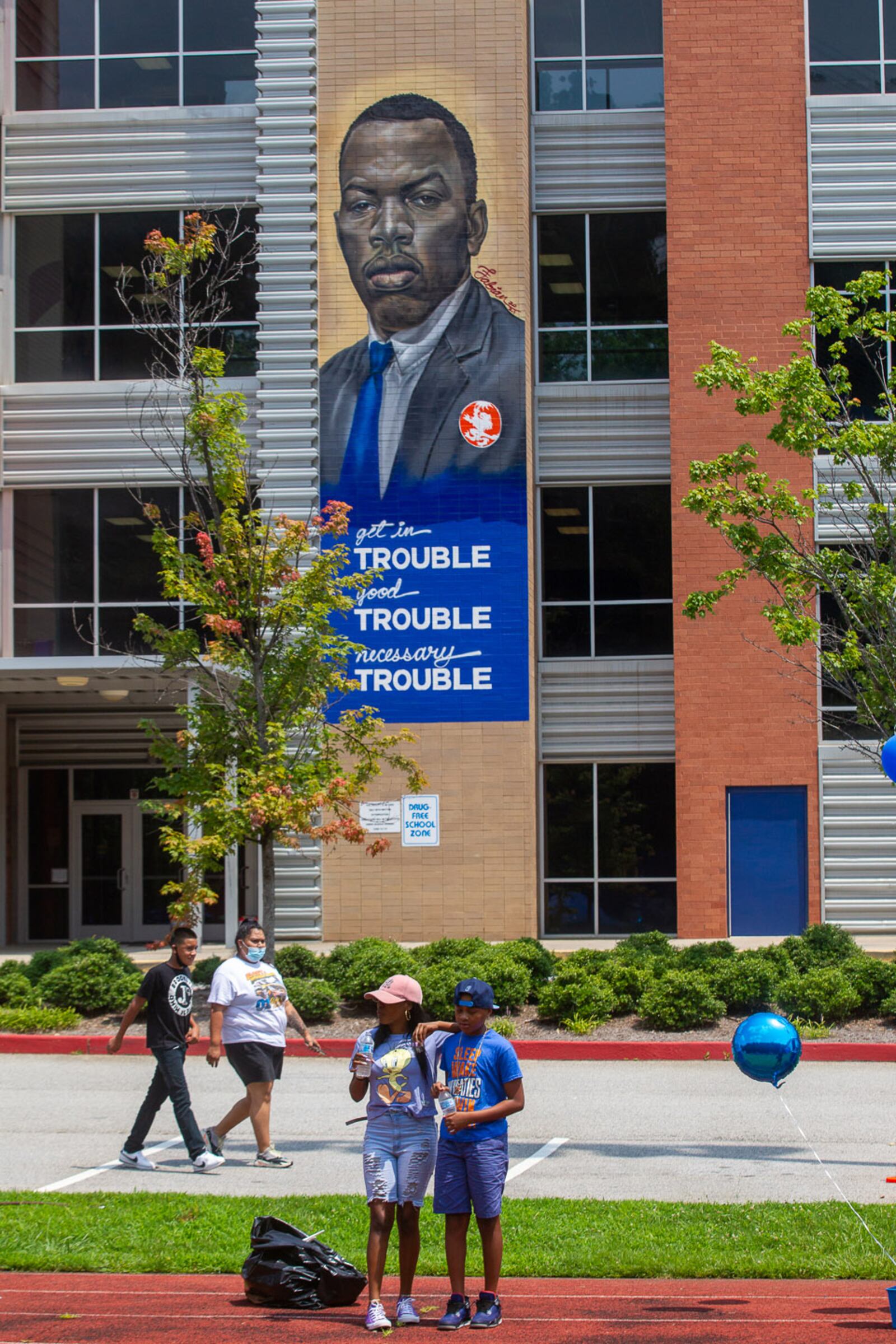 Families walk around to the different tents during the Family Fun Day at John Lewis Invictus Academy in July 2021. (Steve Schaefer for The Atlanta Journal-Constitution)