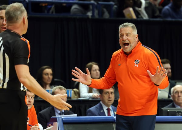 Auburn head coach Bruce Pearl, right, makes a point with a referee during the first half in the second round of the NCAA college basketball tournament against Creighton in Lexington, Ky., Saturday, March 22, 2025. (AP Photo/James Crisp)