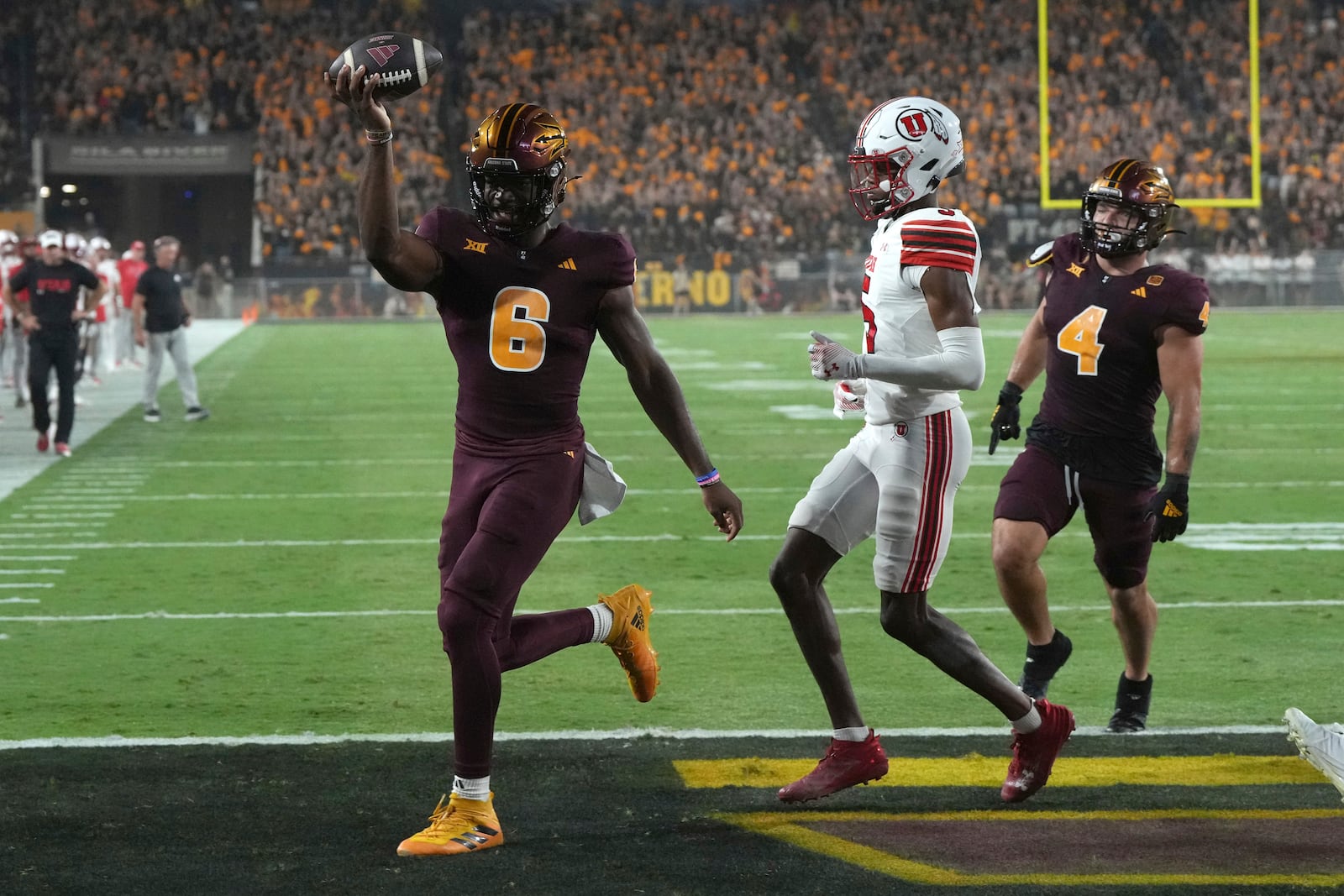 Arizona State quarterback Jeff Sims scores a touch down while getting escorted by running back Cam Skattebo (4) in front of Utah cornerback Zemaiah Vaughn in the first half during an NCAA college football game, Friday, Oct. 11, 2024, in Tempe, Ariz. (AP Photo/Rick Scuteri)