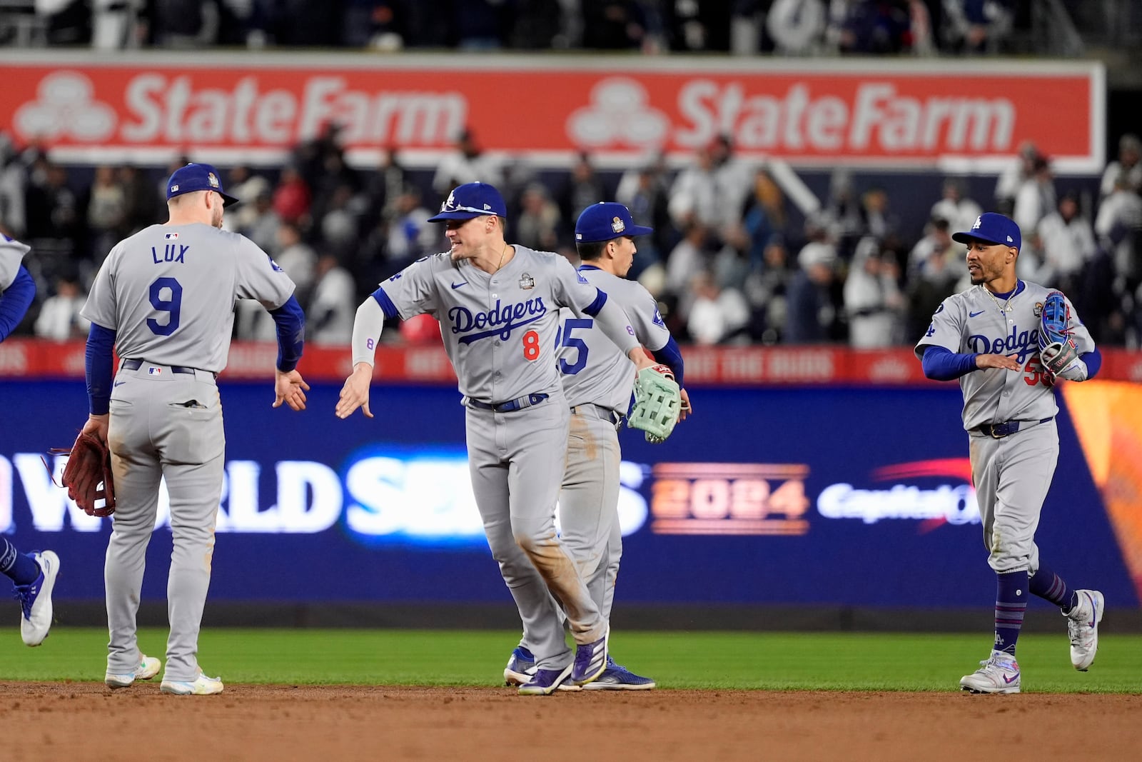 Los Angeles Dodgers' Gavin Lux (9), Kiké Hernández (8), Tommy Edman (25) and Mookie Betts (50) celebrate after Game 3 of the baseball World Series against the New York Yankees, Monday, Oct. 28, 2024, in New York. The Yankees won 4-2. (AP Photo/Godofredo A. Vásquez)