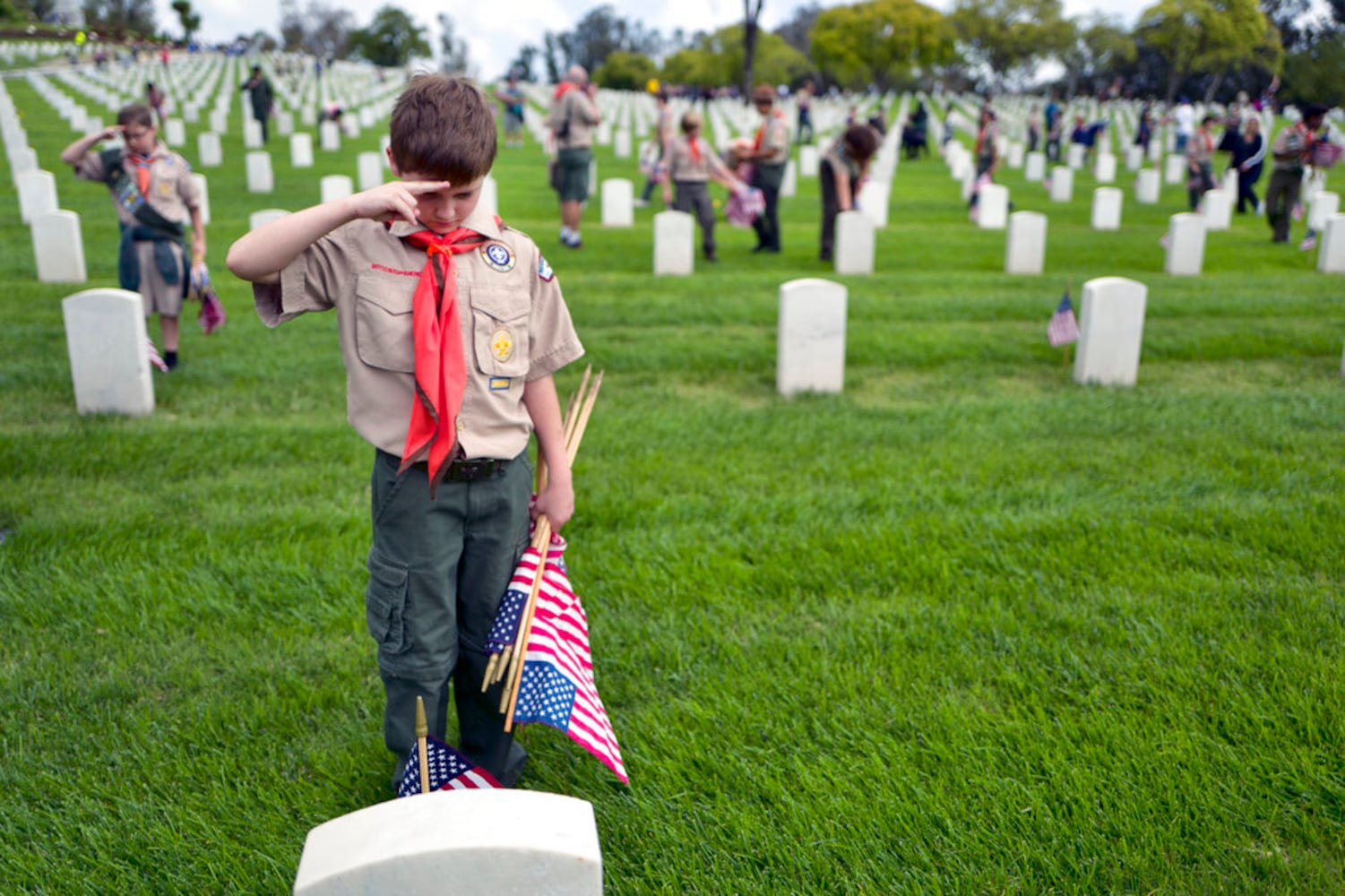 scouts place flags at veteran graves to honor memorial day