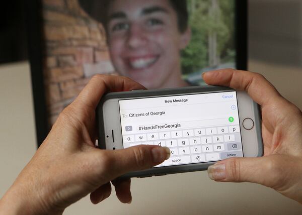 June 28, 2018 Madison: Mandi Sorohan types out the text message #HandsFreeGeorgia by a photograph of her son, Caleb, in her office on Thursday, June 28, 2018, in Madison. Sorohan has been fighting for tougher distracted driving laws in Georgia since Caleb died in an accident while texting in 2009.    Curtis Compton/ccompton@ajc.com