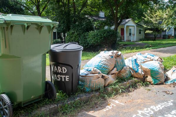 Trash cans and biodegradable bags full of yard trimmings sit undisturbed outside of a house in Atlanta’s Kirkwood community, Thursday, August 5, 2021.  (Alyssa Pointer/Atlanta Journal Constitution)