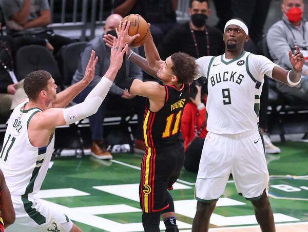 Milwaukee Bucks defender Brook Lopez, left, forces a turnover by Atlanta Hawks guard Trae Young.   “Curtis Compton / Curtis.Compton@ajc.com”