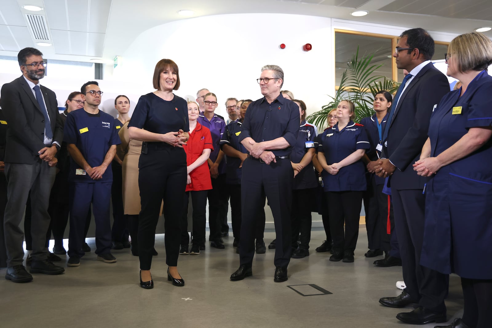 Britain's Prime Minister Keir Starmer and Chancellor Rachel Reeves with members of staff, during a visit to University Hospital Coventry and Warwickshire, in Coventry, England, Thursday, Oct. 31, 2024. (AP Photo/Darren Staples, pool)