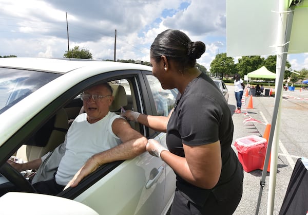 In this file photo, Tom Keating of Decatur, gets his flu shot from Claudina Prince RN, with DeKalb County Board of Health, during the 2nd Annual Drive-Thru Flu Shot Clinic at parking lots of Northlake Mall last September. HYOSUB SHIN / HSHIN@AJC.COM