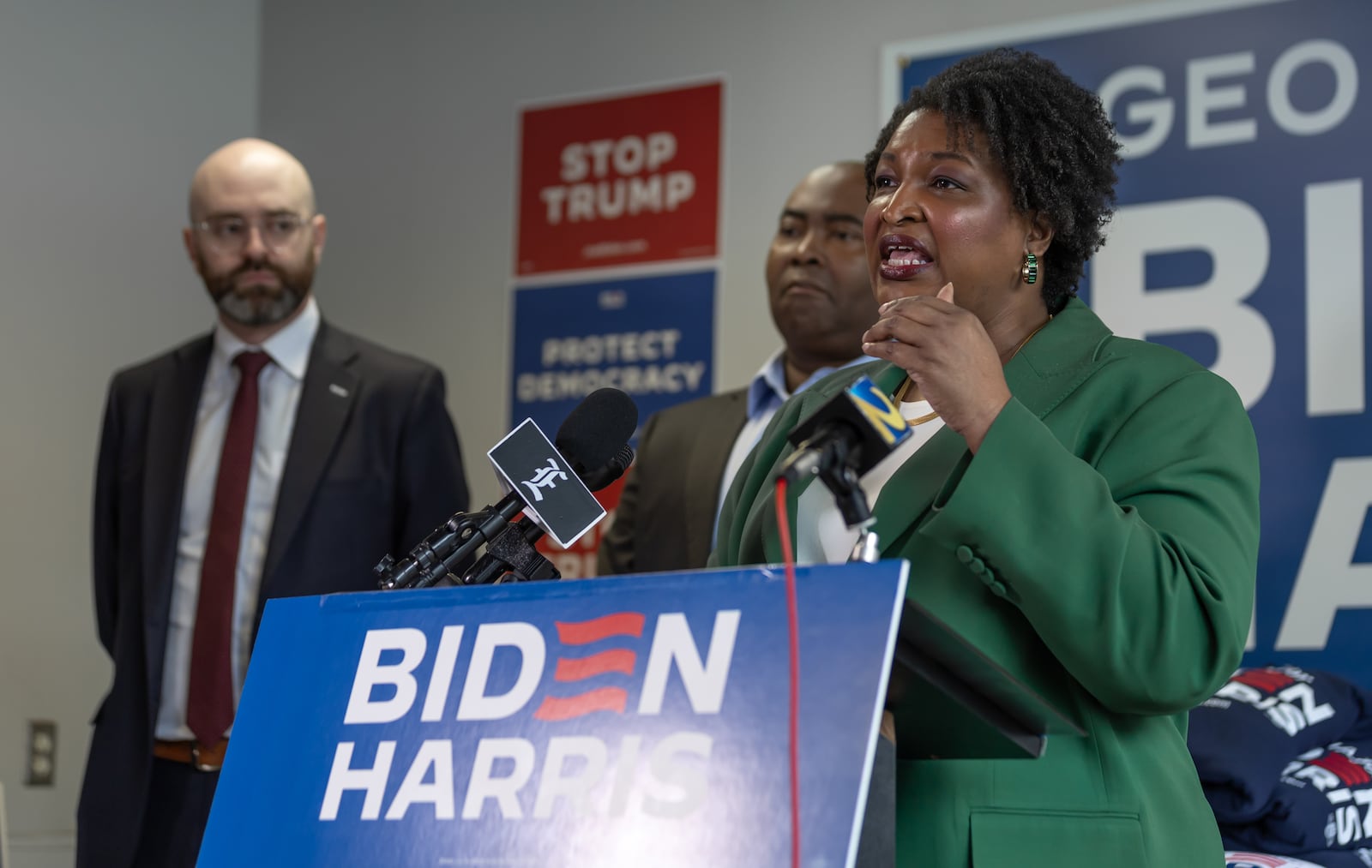 State Sen. Josh McLaurin, left, and Democratic National Committee Chair Jaime Harrison, listen as former gubernatorial candidate Stacey Abrams speaks during a post-presidential debate press conference. (John Spink/AJC)