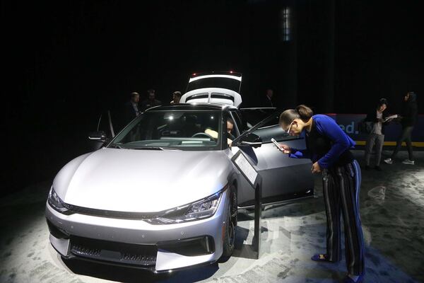 A visitor at Enmarket Arena in Savannah takes a photo of the info sheet for the 2023 Kia EV 6 GT on Tuesday October 25, 2022 during the community celebration for the future Hyundai Motor Group electric vehicle factory near the Georgia coast.