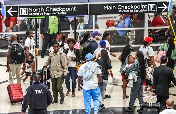 Travelers stream into Hartsfield-Jackson International Airport at the start of Labor Day weekend.