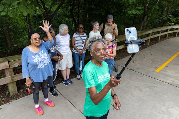 Carolyn Hartfield (center), leader of a walking group, closes out a walking session with in-person and virtual participants at Mason Mill park in Decatur. (Arvin Temkar / AJC)