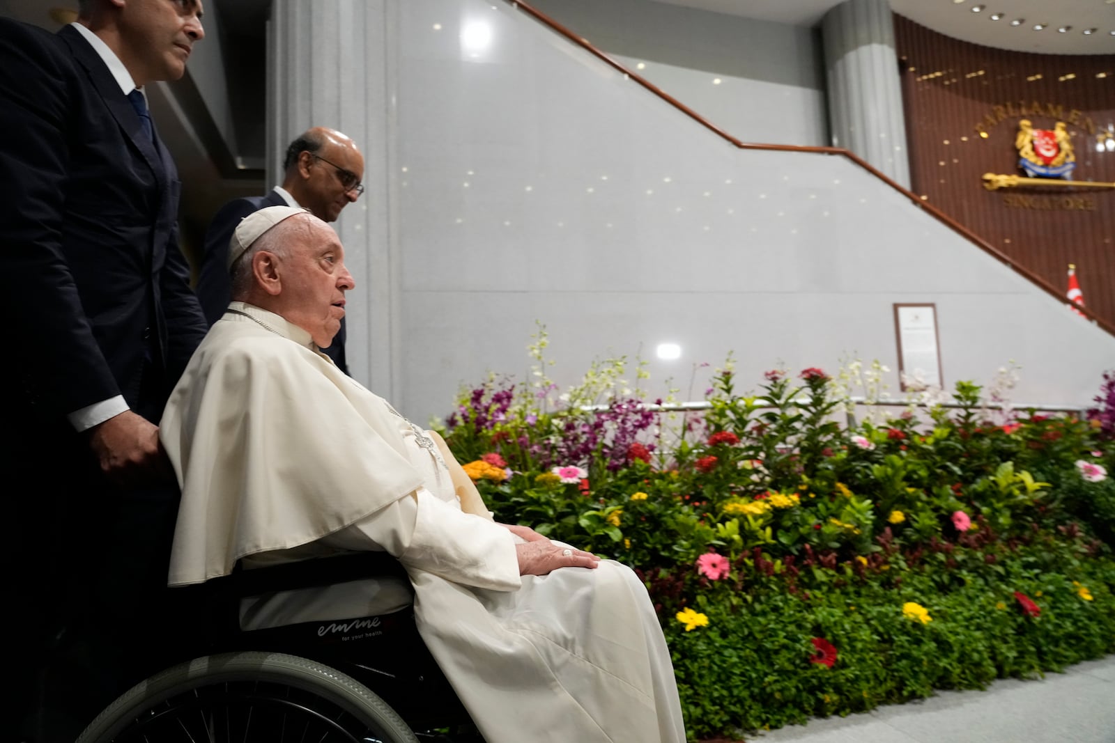 Pope Francis arrives with the President of the Singapore Republic Tharman Shanmugaratnam, third from left, for a visit to the Parliament House in Singapore, Thursday, Sept. 12, 2024. Pope Francis flew to Singapore on Wednesday for the final leg of his trip through Asia, arriving in one of the world's richest countries from one of its poorest after a record-setting final Mass in East Timor. (AP Photo/Gregorio Borgia)