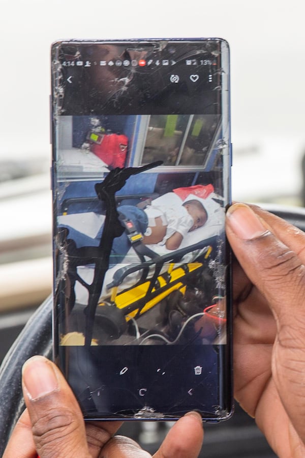 Kevin Johnson, the father of kindergartner Kai Johnson, shows a photo of his son in an ambulance. Kai was shot by a BB pellet.