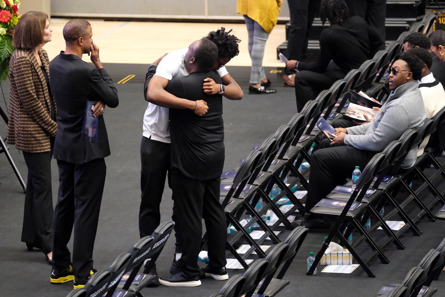 People hug before a celebration of life for former Kennesaw State University basketball coach Amir Abdur-Rahim at the KSU convocation center on Sunday, Oct. 27, 2024.   Ben Gray for the Atlanta Journal-Constitution