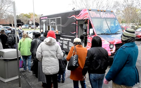 Women line up at The Improper Pig's food truck, The Oinker, to receive lunch outside the Salvation Army's Center of Hope in Charlotte, N.C., on March 14, 2017. (David T. Foster III/Charlotte Observer/TNS)