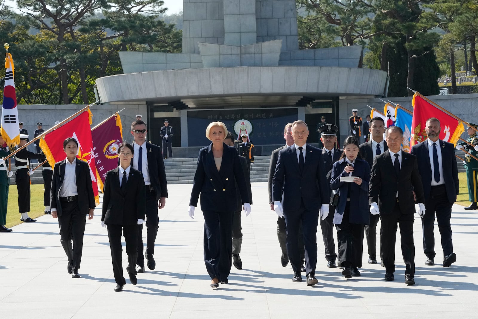 Polish President Andrzej Duda, center right, and his wife Agata Kornhauser-Duda, center left, visit the National Cemetery in Seoul, South Korea, Thursday, Oct. 24, 2024. (AP Photo/Ahn Young-joon)