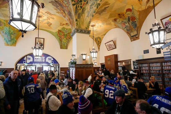 New York Giants supporters enjoy the day inside the traditional 'Hofbraeuhaus' in Munich, Germany, Saturday, Nov. 9, 2024 ahead of the NFL match between the Carolina Panthers and the New York Giants in Munich on Sunday. (AP Photo/Matthias Schrader)