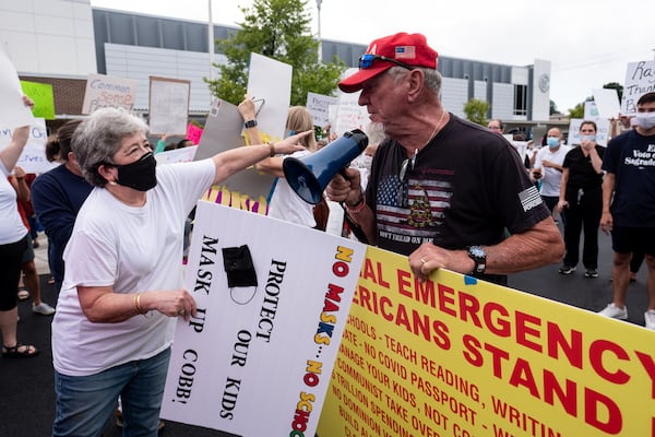 In this file photo, people in favor of and against a mask mandate for Cobb County schools recently gathered and protested ahead of a school board meeting in Marietta. Ben Gray for The Atlanta Journal-Constitution