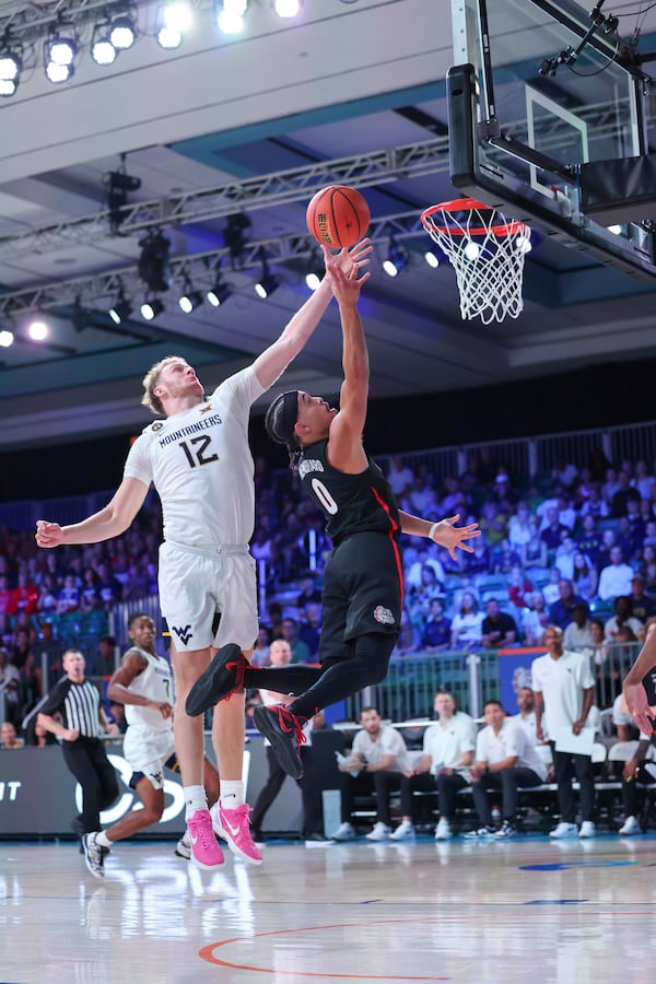 In this handout provided by Bahamas Visual Services, Gonzaga guard Ryan Nembhard (0) goes to the basket against West Virginia guard Tucker DeVries (12) during an NCAA college basketball game at the Battle 4 Atlantis tournament in Paradise Island, Bahamas Wednesday, Nov. 27, 2024. (Tim Aylen/Bahamas Visual Services via AP)