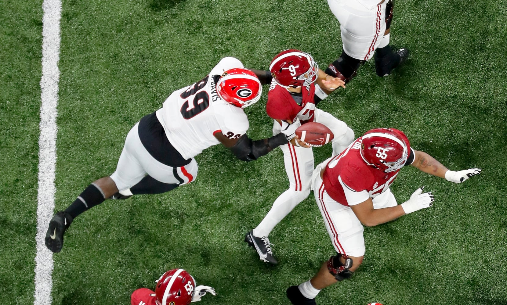 1/10/22 - Indianapolis - Georgia Bulldogs defensive lineman Jordan Davis (99) strips the ball from  Alabama Crimson Tide quarterback Bryce Young (9) in the first quarter.  Georgia recovered and appeared to score but it was ruled an incomplete pass at the 2022 College Football Playoff National Championship  between the Georgia Bulldogs and the Alabama Crimson Tide at Lucas Oil Stadium in Indianapolis on Monday, January 10, 2022.   Bob Andres / robert.andres@ajc.com