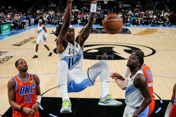 Atlanta Hawks guard Terance Mann (14) dunks against the Oklahoma City Thunder during the first half of an NBA basketball game, Friday, Feb. 28, 2025, in Atlanta. (AP Photo/Mike Stewart)