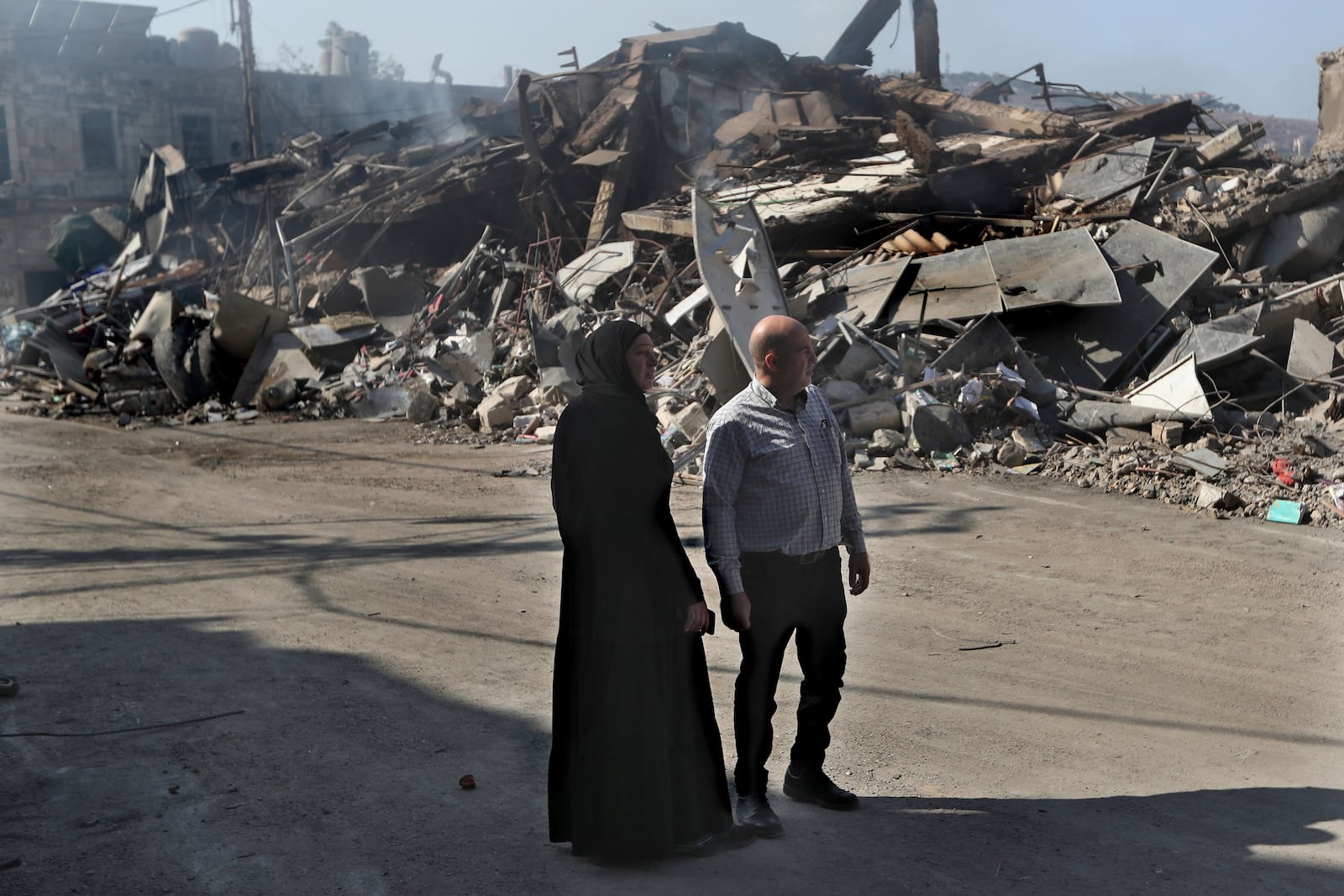 Lebanese citizens watch the destroyed buildings at commercial street that was hit Saturday night by Israeli airstrikes, in Nabatiyeh town, south Lebanon, Sunday, Oct. 13, 2024. (AP Photo/Mohammed Zaatari)