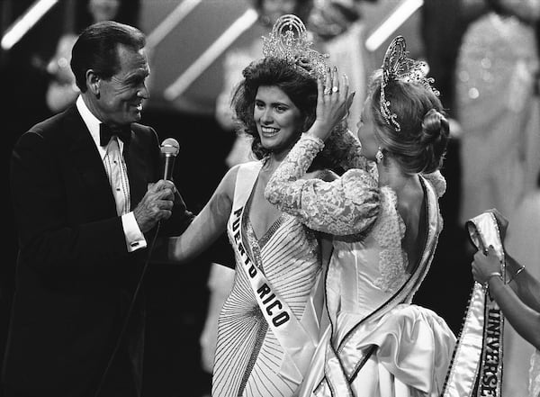 Host Bob Barker watches as Miss Universe of 1985 Deborah Carthy-Deu, of San Juan,  is crowned  in Miami on July 15, 1985. (AP Photo/Raul de Molina)