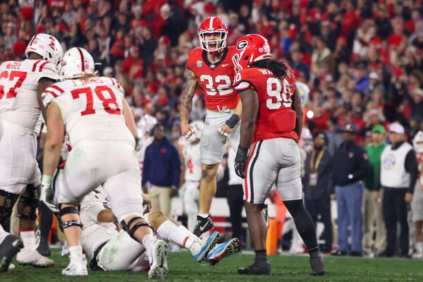 Georgia linebacker Chaz Chambliss (32) and Georgia defensive lineman Tramel Walthour (90) celebrate a defensive stop of Mississippi quarterback Jaxson Dart (left) during the first half at Sanford Stadium, Saturday, November 11, 2023, in Athens, Ga. Georgia won 52-17. (Jason Getz / Jason.Getz@ajc.com)