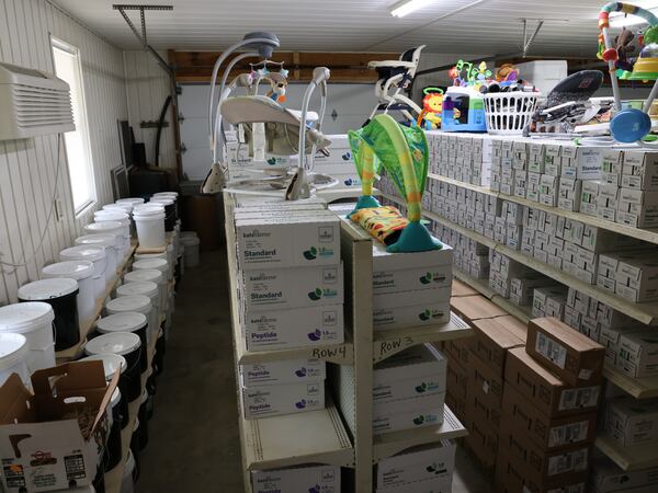 Shelves in the farmhouse garage at King's Cleft ministry are stocked with nutrition formula for the children who lived there, as well as baby chairs and toys. After abuse allegations surfaced earlier this year, the state removed children and disabled adults who lived at the home. (Tyson Horne / Tyson.Horne@ajc.com)