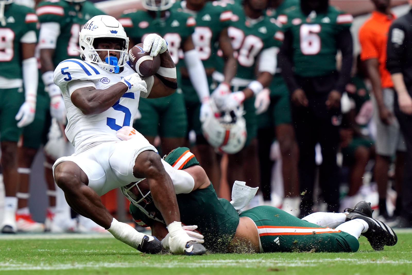 Duke running back Peyton Jones (5) makes a catch for a first down as Miami linebacker Francisco Mauigoa defends during the first half of an NCAA college football game, Saturday, Nov. 2, 2024, in Miami Gardens, Fla. (AP Photo/Lynne Sladky)