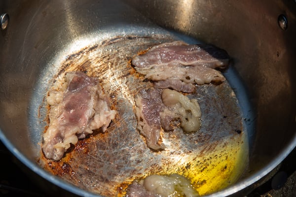 Musa Hasan starts lunch for a group of farmers helping him out by preparing some bacon straight from the farm. Phil Skinner for The Atlanta Journal-Constitution 