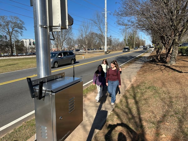 Students walk home past an automated speed camera outside Beacon Hill Middle School in Decatur, Ga., on Tuesday, Feb. 25, 2025. (AP Photo/Jeff Amy)